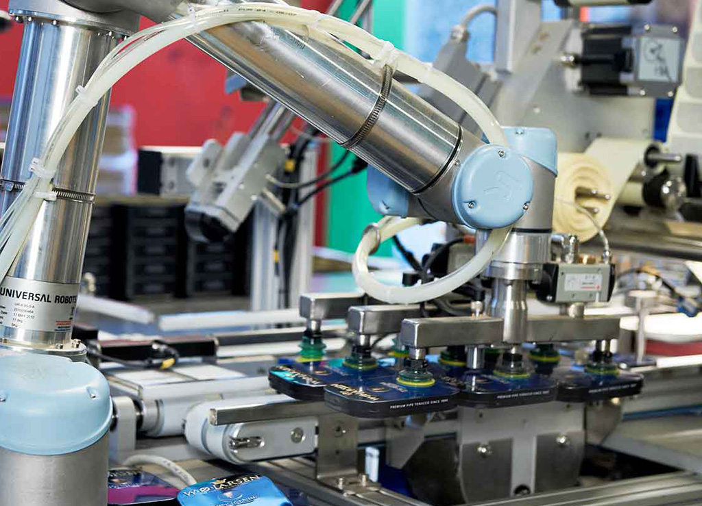 Collaborative robots relieve employees from the strenuous process of preparing bulky packages for large-scale distribution. The added benefit of fenceless-operation allows the robot to work side-by-side with employees on the production lines.